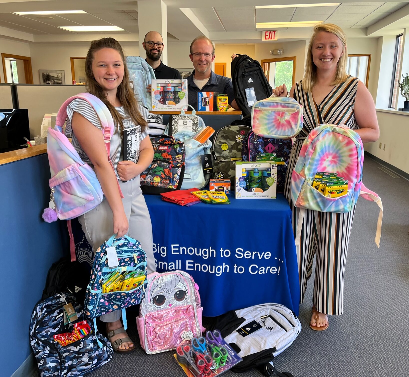 Madison Credit Union Employees Hold Backpacks And School Supplies
